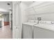 Convenient laundry area equipped with a washer, dryer, and built-in shelving for storage at 30901 Prout Ct, Wesley Chapel, FL 33543