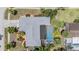 Aerial view of home with a pool, screened-in patio, landscaping, and gray roof at 3230 Player Dr, New Port Richey, FL 34655