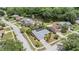 Aerial view of home featuring mature trees, landscaping, nearby lake, and surrounding neighborhood at 3230 Player Dr, New Port Richey, FL 34655