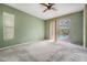 Light-filled bedroom with ceiling fan and sliding glass doors leading to a screened pool area at 3230 Player Dr, New Port Richey, FL 34655