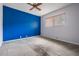 Bedroom featuring a bright blue accent wall, neutral carpet, and a window for natural light at 3230 Player Dr, New Port Richey, FL 34655