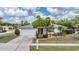 Well-maintained single-Gathering home with lush front yard landscaping and a pristine driveway leading to a two-car garage at 3230 Player Dr, New Port Richey, FL 34655