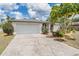 Charming home with white brick facade, attached garage, and mature landscaping in a tranquil neighborhood at 3230 Player Dr, New Port Richey, FL 34655