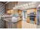 Well-lit kitchen with wood cabinets, stainless steel appliances and breakfast bar at 3230 Player Dr, New Port Richey, FL 34655