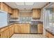 Charming kitchen featuring wood cabinets, stainless steel appliances, and a bright window at 3230 Player Dr, New Port Richey, FL 34655