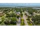 A neighborhood is showcased from above, dotted with trees and houses near a body of water at 3236 San Pedro St, Clearwater, FL 33759