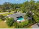 An aerial view of the home featuring a private pool, lush landscaping, and mature trees at 3236 San Pedro St, Clearwater, FL 33759