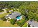 Aerial view of a home with a pool, patio area, mature trees, and a well-manicured lawn at 3236 San Pedro St, Clearwater, FL 33759
