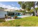 Expansive backyard with pool, green grass, mature trees, and outdoor seating area, perfect for entertaining at 3236 San Pedro St, Clearwater, FL 33759