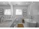 Bathroom featuring double sinks, stand alone tub, and custom patterned tile flooring at 3236 San Pedro St, Clearwater, FL 33759