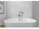 Close up of a white standalone bathtub with chrome fixtures and white tiled wall at 3236 San Pedro St, Clearwater, FL 33759