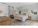Sunlit bedroom with neutral decor, featuring a cozy bed, and a ceiling fan at 3236 San Pedro St, Clearwater, FL 33759