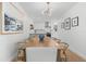 Bright dining room with modern chandelier, wood table and light wood floors leading to the kitchen at 3236 San Pedro St, Clearwater, FL 33759