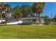 Manicured front yard and landscaping showcase this modern single-story home's curb appeal with a circular driveway at 3236 San Pedro St, Clearwater, FL 33759