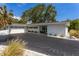 Inviting home exterior with well-maintained landscaping, a black asphalt driveway, and a spacious two-car garage at 3236 San Pedro St, Clearwater, FL 33759
