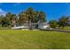 Single-story home featuring a manicured lawn, palm trees, and a circular driveway at 3236 San Pedro St, Clearwater, FL 33759