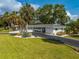 Beautiful single-story home featuring lush landscaping, mature palms, a circular driveway, and an attached garage at 3236 San Pedro St, Clearwater, FL 33759