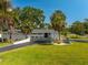 Well-maintained single-story home with palm trees, lush green lawn, circular driveway, and crisp white exterior at 3236 San Pedro St, Clearwater, FL 33759