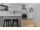 Eat-in kitchen with modern white cabinets, marble backsplash, quartz countertops, stainless appliances, and breakfast bar seating at 3236 San Pedro St, Clearwater, FL 33759