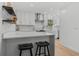 Eat-in kitchen with modern white cabinets, marble backsplash, quartz countertops, stainless hood, and breakfast bar seating at 3236 San Pedro St, Clearwater, FL 33759