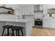 Eat-in kitchen with modern white cabinets, marble backsplash, quartz countertops, stainless appliances, and breakfast bar seating at 3236 San Pedro St, Clearwater, FL 33759