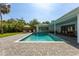 Private backyard oasis featuring an in-ground pool, brick patio, and lush landscaping for a serene escape at 3236 San Pedro St, Clearwater, FL 33759