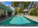 Stunning pool area with lush landscaping, a small playhouse, and inviting outdoor living space at 3236 San Pedro St, Clearwater, FL 33759