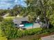 Aerial view of backyard pool, patio with umbrella and seating surrounded by lush landscaping at 3236 San Pedro St, Clearwater, FL 33759