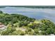Beautiful aerial view of the waterfront community with lush trees, a pond, and walkways along the scenic lake at 3727 Janus Way, Palm Harbor, FL 34685