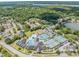 Aerial view featuring community amenities, including a pool, tennis courts, and lush green spaces at 3727 Janus Way, Palm Harbor, FL 34685