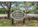 Lansbrook Commons community sign with mature trees, greenery, and neighborhood information at 3727 Janus Way, Palm Harbor, FL 34685