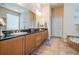 Bathroom featuring a large mirror over a dual sink vanity with wooden cabinets and granite countertops at 3727 Janus Way, Palm Harbor, FL 34685
