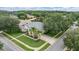 An aerial view of a charming single-story home with mature trees, lush landscaping and a well manicured lawn at 3727 Janus Way, Palm Harbor, FL 34685
