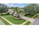 An aerial view of a charming single-story home with mature trees, lush landscaping and a well manicured lawn at 3727 Janus Way, Palm Harbor, FL 34685