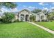 Beautiful home with a manicured front yard and tropical landscaping at 3727 Janus Way, Palm Harbor, FL 34685