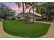 Beautifully landscaped front yard of a home with lush green grass and mature trees at 3727 Janus Way, Palm Harbor, FL 34685