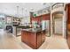 A spacious kitchen boasts dark wood cabinets, stainless steel appliances, and a central island with granite countertops at 3727 Janus Way, Palm Harbor, FL 34685