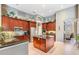 A spacious kitchen featuring stainless steel appliances, a central island, granite countertops, and dark wood cabinets at 3727 Janus Way, Palm Harbor, FL 34685