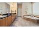 Elegant bathroom with dual sink vanity, soaking tub, and tiled flooring, offering a luxurious feel at 3727 Janus Way, Palm Harbor, FL 34685