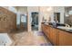 Bright bathroom featuring a soaking tub, walk-in shower with glass doors, and dual sink vanity at 3727 Janus Way, Palm Harbor, FL 34685