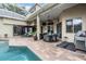 Outdoor patio area with dining set, lounge seating, grill, and view of the pool at 3727 Janus Way, Palm Harbor, FL 34685