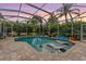 Sparkling pool featuring in-water lounge chairs and a serene, screened-in enclosure at 3727 Janus Way, Palm Harbor, FL 34685