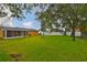 A large backyard with a fire pit and a screened-in porch on an exterior yellow house at 404 12Th Sw St, Ruskin, FL 33570