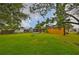 A large backyard with a fire pit and a screened-in porch on an exterior yellow house at 404 12Th Sw St, Ruskin, FL 33570