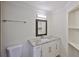 Bathroom featuring a white vanity with granite countertop, decorative mirror, and convenient open shelving at 404 12Th Sw St, Ruskin, FL 33570