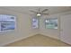 Bright bedroom with tile flooring, three windows and a modern ceiling fan at 404 12Th Sw St, Ruskin, FL 33570