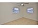 Sunlit bedroom with two windows, tile flooring, and neutral paint, offering a comfortable and inviting space at 404 12Th Sw St, Ruskin, FL 33570