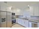 Modern kitchen featuring stainless steel appliances, granite countertops, white cabinetry and tile backsplash at 404 12Th Sw St, Ruskin, FL 33570