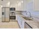 Updated kitchen with stainless steel appliances, granite countertops, and new white cabinets at 404 12Th Sw St, Ruskin, FL 33570