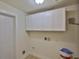 Well-lit laundry room with white cabinets and utility connections, designed for efficient laundry management at 404 12Th Sw St, Ruskin, FL 33570